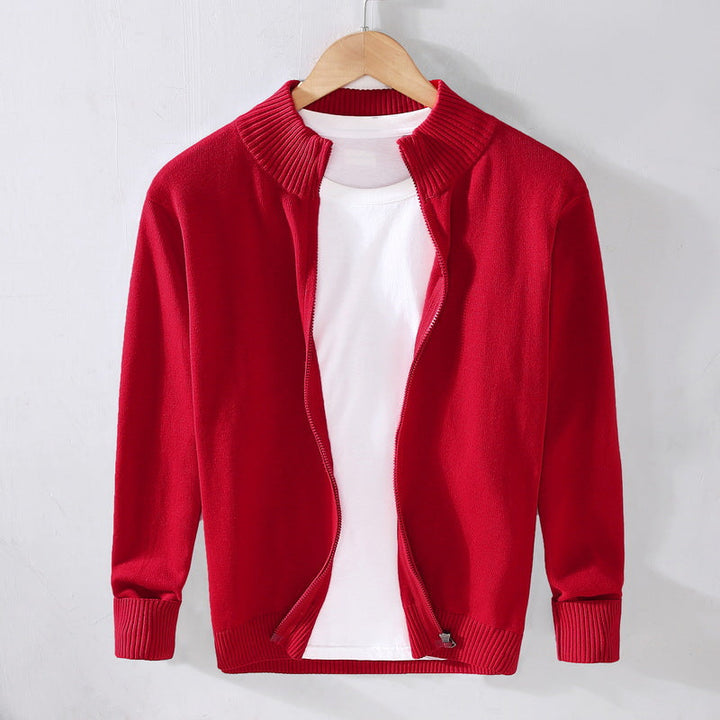 Cardigan rosso aperto su maglietta bianca appesa a gruccia, moda casual uomo, abbigliamento autunnale, stile elegante e moderno.