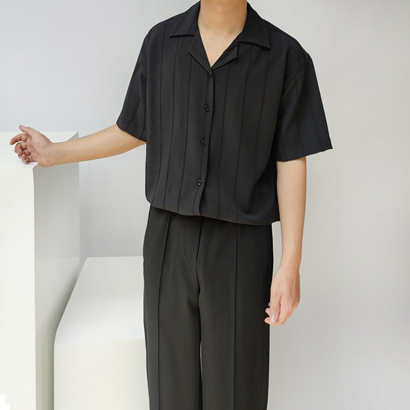 Camicia nera a maniche corte con colletto aperto e pantaloni abbinati. Moda uomo elegante, abbigliamento estivo casual, stile minimalista.