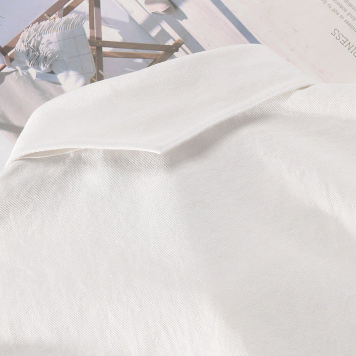 Camicia bianca in cotone su sfondo di riviste, tessuto morbido e leggero, moda elegante, abbigliamento casual, stile minimalista.