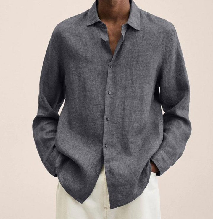 Camicia lino grigia uomo, maniche lunghe, abbinata a pantaloni bianchi. Moda maschile elegante, stile casual chic.
