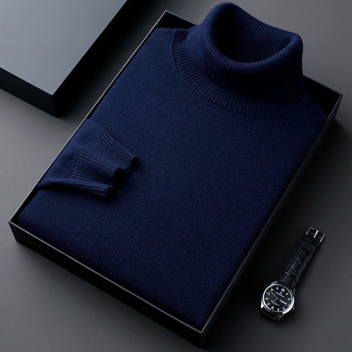 Maglione dolcevita blu scuro in scatola regalo, elegante e raffinato, accanto a un orologio da polso nero. Moda uomo, abbigliamento invernale.