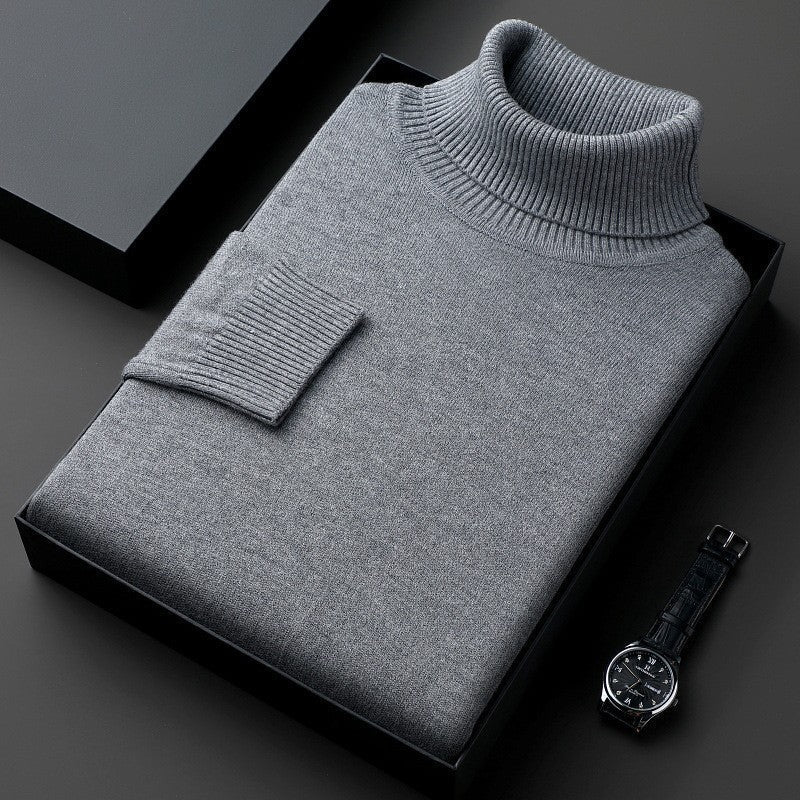 Maglione dolcevita grigio piegato in scatola nera, accanto a orologio da polso elegante. Moda uomo, abbigliamento invernale, stile classico.