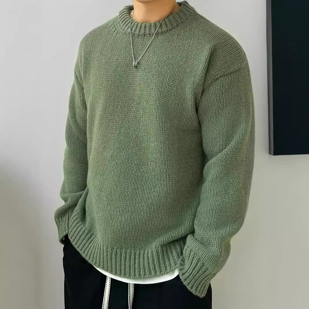 Maglione verde oliva in lana, indossato da uomo con collana argento, stile casual. Abbigliamento autunnale, moda maschile, tendenza 2023.
