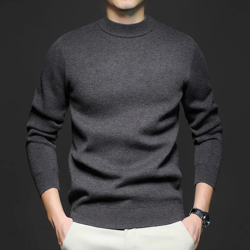 Maglione uomo grigio scuro in lana, maniche lunghe, indossato con pantaloni chiari. Stile casual elegante, moda autunno inverno.