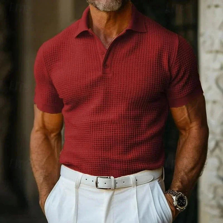 Uomo in polo rossa elegante, pantaloni bianchi, orologio da polso. Moda maschile estiva, stile casual chic, abbigliamento di tendenza.