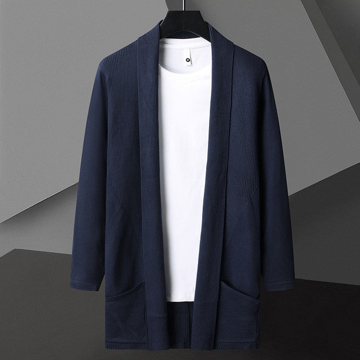 Cardigan blu scuro da uomo su gruccia, con maglietta bianca sotto. Moda maschile elegante, abbigliamento casual, stile minimalista.