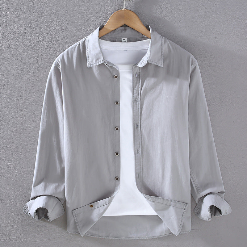 Camicia grigia da uomo in cotone, maniche lunghe, su gruccia. Design casual, abbinata a t-shirt bianca. Moda maschile, abbigliamento elegante.