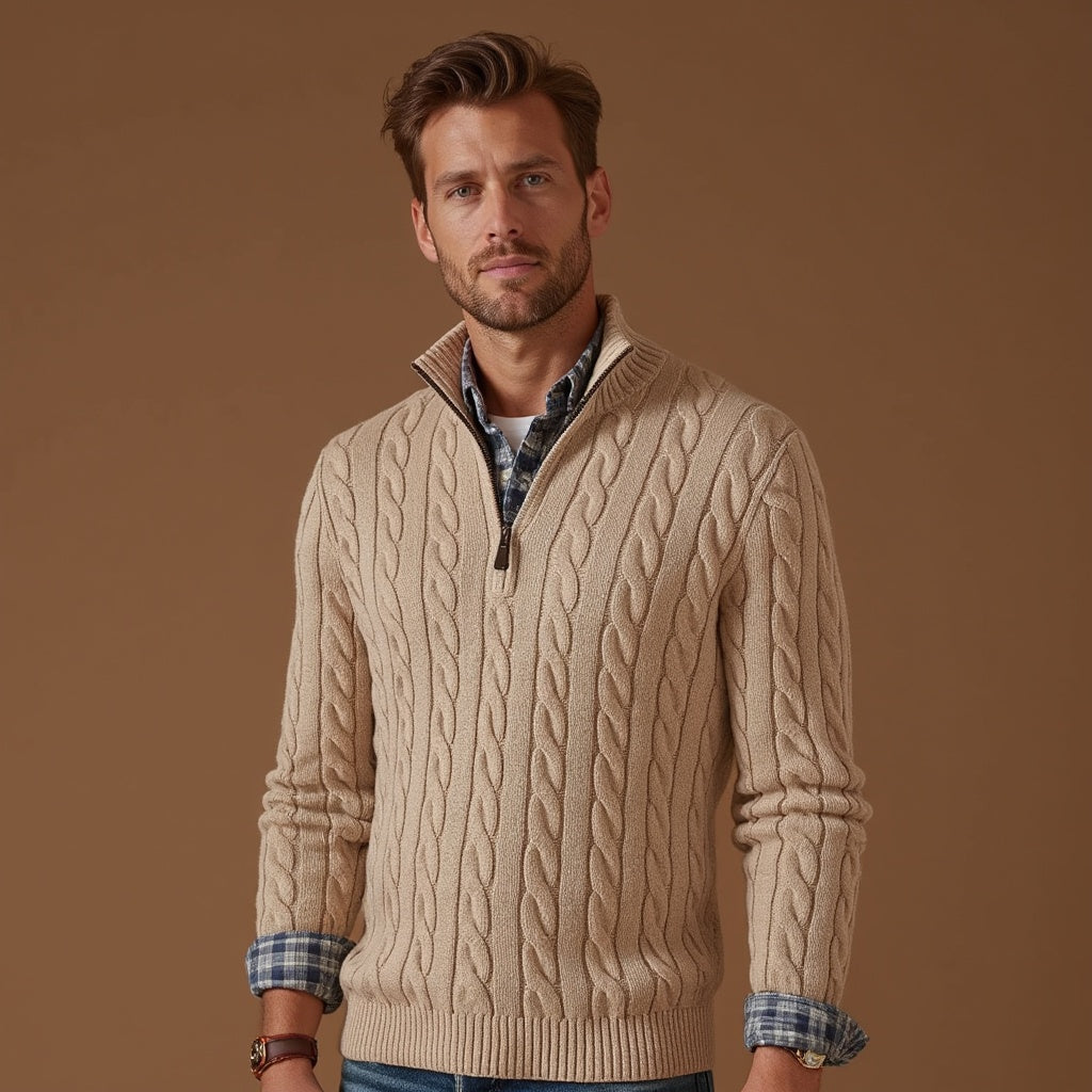 Uomo con maglione beige a trecce, collo alto con zip, camicia a quadri blu sotto. Moda autunnale, abbigliamento casual elegante. Sfondo marrone.
