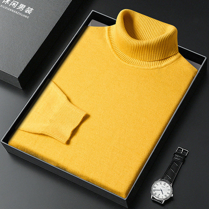 Maglione giallo a collo alto in scatola regalo nera, orologio da polso elegante accanto. Maglione invernale uomo, moda casual, abbigliamento caldo.