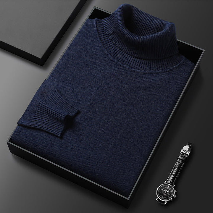Maglione dolcevita blu scuro in scatola nera su sfondo grigio, accanto a orologio da polso elegante. Moda uomo, abbigliamento invernale di lusso.